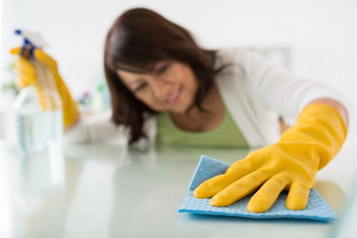 Office cleaning service sanitizing shared work areas and meeting rooms